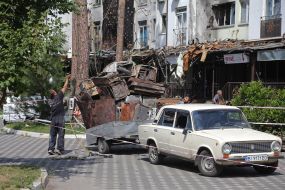 A man loads scrap metal into a trailer in Irpen