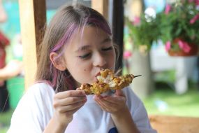 Девочка ест шашлык в "Железном городке" в Ирпене