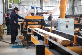 Оператор на станке распиливает древесину