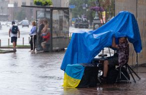 Вуличний музикант ховається від дощу