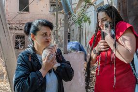 Women hold kittens rescued from a house destroyed by shelling by Russian troops, in Kharkov
