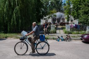 A man on a bicycle near the House of Culture in the village of Yagidne, Chernihiv region
