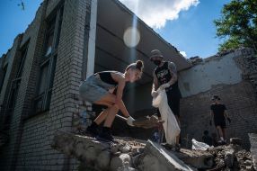 Volunteers clean up the rubble of the House of Culture in the village of Yagidne, Chernihiv region