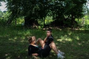 Young people rest after cleaning the debris of the House of Culture in the village of Yagidne, Chernihiv region