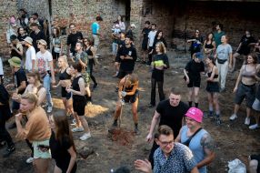 Volunteers clean up the rubble of the House of Culture in the village of Yagidne to the accompaniment of electronic music