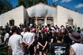 Volunteers clean up the rubble of the House of Culture in the village of Yagidne to the accompaniment of electronic music