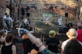 Volunteers clean up the rubble of the House of Culture in the village of Yagidne to the accompaniment of electronic music