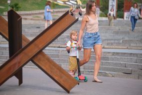 A woman with a boy near an anti-tank hedgehog