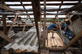 Restoration work on the roof of a multi-story building damaged by the shelling of the occupiers