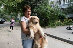 A woman carries her dog