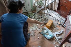 A woman collects projectile fragments in an apartment