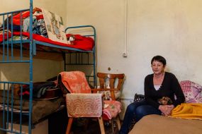 A forced migrant with a dog in a hostel