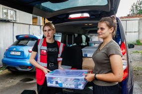 Volunteers unload medicines to residents of a hostel for displaced people