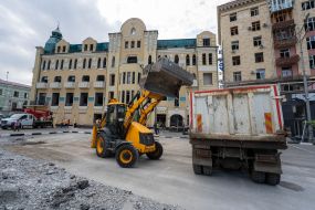 Трактор грузит разбитый асфальт возле Дома недвижимости