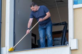A man cleans broken glass in the Real Estate House