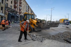 Рабочие убирают разбитые стекла и мусор возле Дома недвижимости