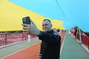 Сотрудник полиции делает селфи под флагом Украины