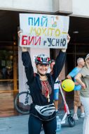 A female volunteer holds a poster during a charity bike ride