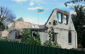 The flag of Ukraine above a destroyed residential building in the city of Bucha