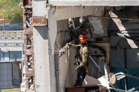 Спасатели разбирают стену здания, взорванного российской ракетой С-300, в Харькове