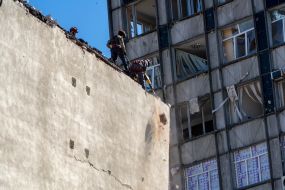 Спасатели разбирают стену здания, взорванного российской ракетой С-300, в Харькове