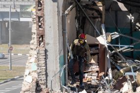 Спасатели разбирают стену здания, взорванного российской ракетой С-300, в Харькове
