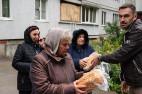 A volunteer distributes humanitarian aid to people