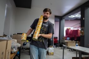 A volunteer puts canned food into boxes