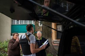 A volunteer distributes humanitarian aid to people