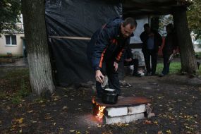 Due to the lack of gas and electricity supply, residents cook food in the yard on a fire in the village. Chkalov