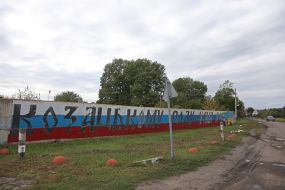 Местные жители перекрашивают забор в цвета украинского флага