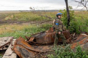 A soldier of the National Guard of Ukraine near an exploded Russian tank