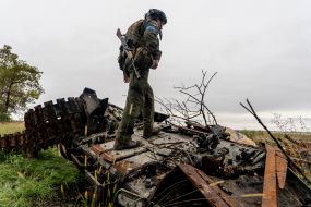 Soldier of the National Guard of Ukraine on a broken Russian tank