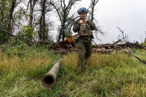 A soldier of the National Guard of Ukraine near an exploded Russian tank