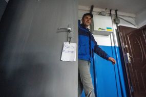 The man leaves the apartment in a house damaged by a MLRS salvo