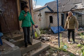 People near their dilapidated house in the village of Prudyanka