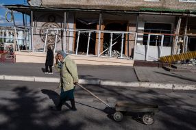 Elderly woman with a cart in the de-occupied Izyum city