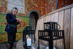 A woman lights a lamp