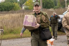 A soldier of the National Guard of Ukraine helps to unload humanitarian cargo in the village of Dubovka