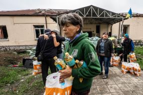 A woman carries a package with humanitarian aid