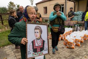 A local resident shows a portrait of the Ukrainian poetess Lesa Ukrainka, miraculously preserved during the Russian occupation
