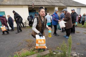 A woman carries a package with humanitarian aid