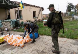 Serviceman of the National Guard of Ukraine helps to unload humanitarian cargo