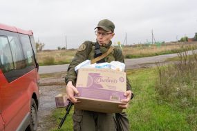 A soldier of the National Guard of Ukraine helps to unload humanitarian cargo in the village of Dubovka