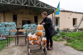 A local resident stacks packages with humanitarian aid on a cart