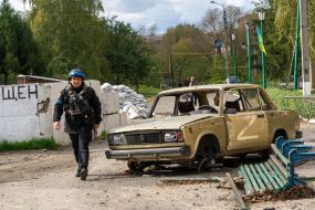 Сотрудник полиции проходит возле автомобиля в Купянске