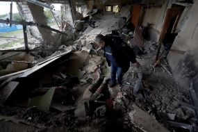 Сотрудник полиции возле трупа российского солдата в селе Петропавловка