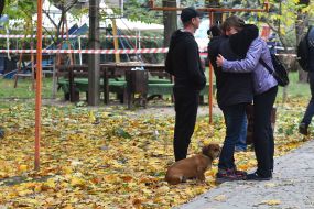 People cry near a residential building destroyed by a Russian missile