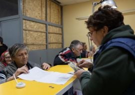 Пожилая женщина получает пенсию в Изюме