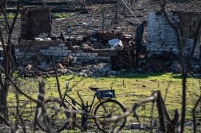 Местный житель возле разрушенного дома
